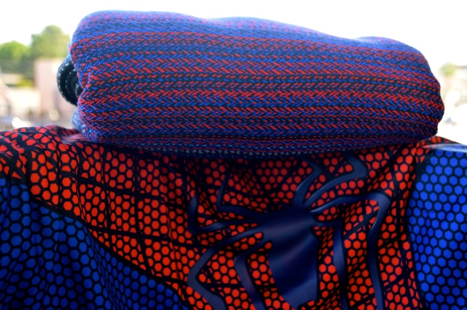 Image shows the black, red, and blue wrap folded neatly atop a red and blue shirt with blue spider-man logo in the center.